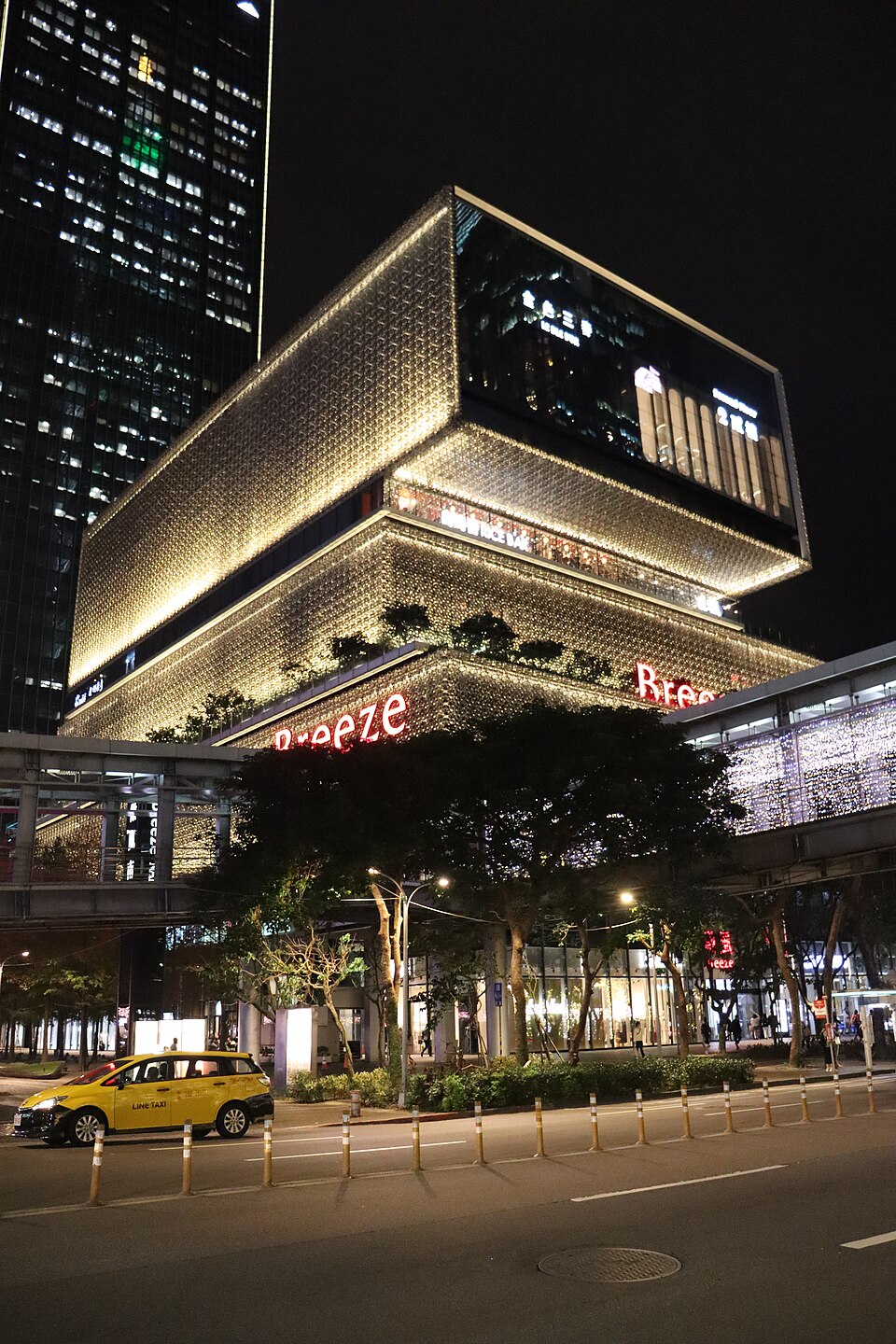2024年12月5日微風南山建築外觀夜景，街邊有計程車，並非CÉ LA VI室內或2026萬聖派對現場。